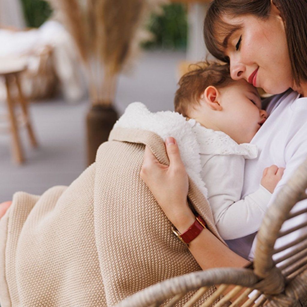 Dvojvrstvá vyteplená pletená deka BabyOno na bábätku v maminom náručí